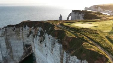 Güneş, Atlas Okyanusu 'nun üzerinde batarken Fransa' nın Normandiya kentindeki Etretat 'ın nefes kesici uçurumlarına tanık olun. Bu büyüleyici manzara doğanın güzelliğini ve çekiciliğini sergiliyor..