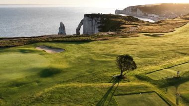 Etretat, Normandiya 'da unutulmaz bir golf deneyimi yaşayın. Güneş dramatik uçurumların ve okyanusların üzerinde batarken bu çarpıcı manzaranın güzelliklerini gözler önüne seriyor..