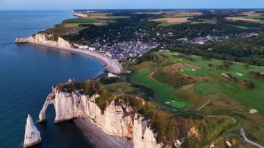 Güneş dramatik uçurumların ve sakin suların üzerinde batarken Normandiya 'daki Etretat' ın çarpıcı güzelliğini tecrübe edin. Resimli manzaraya ve aşağıdaki büyüleyici köye hayran kaldım..