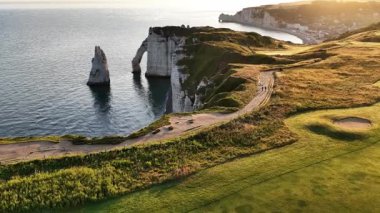 Güneş okyanusun üzerinde batarken Normandiya 'daki Etretat' ın nefes kesici uçurumlarını keşfedin. Bu pitoresk mekan, sahilin doğal güzelliğini ve huzur dolu atmosferini gösteriyor..