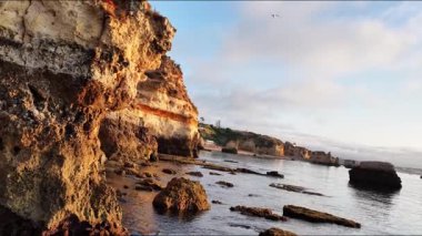 Güneş görkemli kaya oluşumları ve sakin suların üzerinde batarken Portekiz 'in Algarve kentinin nefes kesici kıyı şeridini deneyimleyin. Bu doğal cennetin güzelliğinin tadını çıkar..