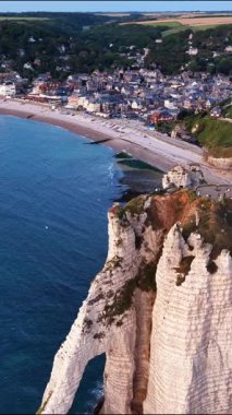 Etretat 'ın çarpıcı hava perspektiflerini keşfedin, görkemli tebeşir kayalıklarını ve deniz kenarındaki büyüleyici köyünü sergileyin. Bu ikonik varış yerinin huzurlu güzelliğini tecrübe et..