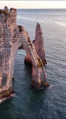 Fransa 'nın Etretat kentindeki nefes kesen uçurumları keşfedin. Eşsiz kaya oluşumlarını ve sakin okyanusu vurgulayın. Gün batımında doğa harikası deneyimi.