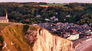 Etretat 'ın çarpıcı hava manzarasını, dramatik beyaz uçurumları ve tuhaf bir köyü deneyin. Güneş doğanın doğal güzelliğini vurgulayarak doğanın üzerinde batar..