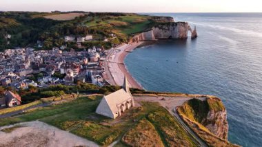 Etretat, Fransa 'nın nefes kesici güzelliğini keşfedin, dramatik uçurumlarını, sakin plajlarını ve büyüleyici köyünü sergileyin. Gün batımında mükemmel bir görsel yolculuk..