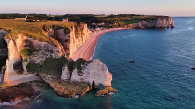 Fransa 'nın Etretats sahil şeridinin çarpıcı güzelliğini yukarıdan deneyimleyin. Uçurumlar parlak mavi denizden görkemli bir şekilde yükselirler, doğanın özünü yakalarlar günbatımında sanatın özünü..
