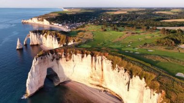 Fransa 'daki Etretat' ın nefes kesen uçurumlarını keşfedin, dramatik kaya oluşumları ve kıyı şeridi boyunca yemyeşil alanlar. Gün batımında bu ikonik konumun dingin güzelliğini hissedin..