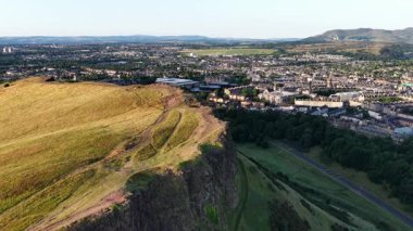 Güneş ikonik Arthur Koltuğu 'nun üzerinde batarken Edinburgh' un çarpıcı panoramik manzarasını deneyimleyin..