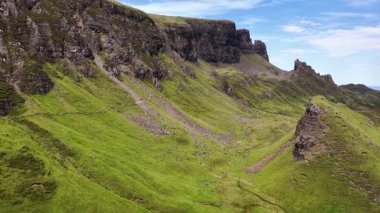 İskoçya 'nın üzerinde süzülen Skye adası göz kamaştırıcı uçurumları ve açık mavi gökyüzünün altındaki yemyeşil arazileri gözler önüne seriyor. Bu ikonik konumun dramatik doğal güzelliğini havadan deneyimleyin..