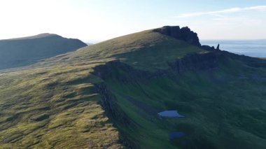 İskoçya 'daki Skye Adası' nın göz kamaştırıcı hava manzarasına tanık olun. Görkemli tepeleri, kayalık uçurumları ve berrak mavi gökyüzü altında sakin su kütleleri..