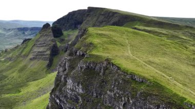 İskoçya 'daki Skye Adası' nın nefes kesici güzelliğini yukarıdan keşfedin. Hava perspektifi dramatik uçurumlar ve yeşil tepeler sergiliyor ve adanın doğal ihtişamını vurguluyor..