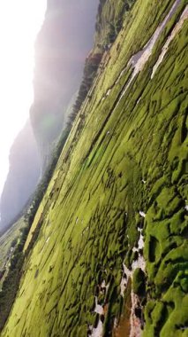 Ilse of Skye 'ın büyüleyici hava manzarasını deneyin, yemyeşil manzaraları, engebeli dağları ve sakin su yansımalarını gösterin. Gökyüzünden yansıyan doğa güzelliği.