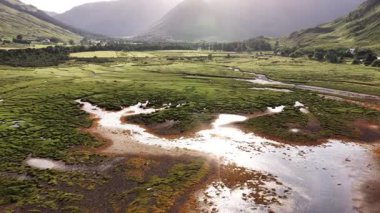 İskoçya 'nın Skye kentindeki büyüleyici hava manzarasını keşfedin, verimli yeşil tarlalar, dolambaçlı nehirler ve yumuşak güneş ışığı altında sakin su kütleleri sergilenmektedir. Doğa aşıkları için mükemmel..