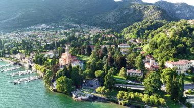 Bereketli yeşilliğin büyüleyici mimariyle buluştuğu Tremezzo 'daki Como Gölü' nün nefes kesici hava manzarasını deneyin. Sakin sular etrafındaki dağların güzelliğini yansıtır..