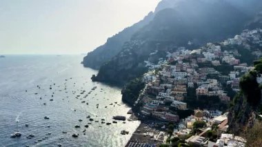 Positano 'nun gündüzleri geceye dönüşürken nefes kesici dönüşümüne tanık olun. Kayalıklarda yuva yapmış renkli köy teknelerle ve parıldayan sularla canlanıyor, eşsiz cazibesini sergiliyor..