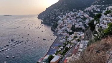 Amalfi Sahili 'ndeki Positano' nun büyüleyici dönüşümüne tanık olun. Gün geceye dönerken. Tekneler limanda dinlenirken renkli evler kayalıklara sarılıp büyüleyici bir panoramik manzara yaratıyor..