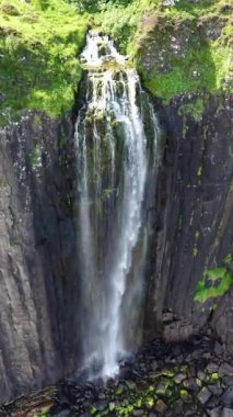 Skye İskoçya Adası 'ndaki bir şelalenin nefes kesici güzelliğini keşfedin. Bu hava yolculuğu, verimli yeşilliklerle çevrili kayalıkların üzerinden zarif bir şekilde akan suyu yakalar..