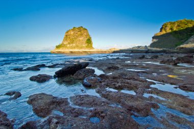 Rocky Sahil Hattı Şafakta Huzurlu Okyanus Suyu ile Tanjung Bloam Plajı Lombok Endonezya 'da Gelgit Havuzu ve Uzak Adaları Güzelce Buluştu