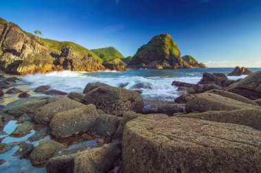 Okyanus Dalgaları, Telawas Plajı Lombok Endonezya 'da Arkaplanda Görkemli Kıyı Arazisi ile Kayalara Çarpışıyor