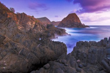 Rocky Sahili Okyanus Dalgaları Mor Gökyüzü ve Dramatik Uçurumlarla Gün Batımında Telawas Sahili Lombok Endonezya 'da Güzelce Karşılaşıyor