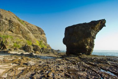 Kıyı Kaya oluşumları, Alçak Gelgit 'te açık mavi bir gökyüzünün altında okyanustan ortaya çıkar..