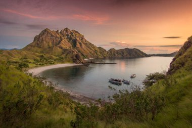 Tranquil Körfezi, Komodo Bölgesi, Labuan Bajo Endonezya 'da Lush Hills ve Sakin Su ile Gün Batımında Tekneleri Kucaklıyor.