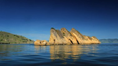 Tranquil Bay Reflects Majestic Rock Formations at Sunrise: Exploring Coastal Serenity and Island Wonders in Padar Island, Komodo District, Labuan Bajo Indonesia. clipart