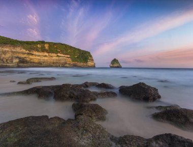 Coastal Cliffs Sunset 'te Okyanus Dalgaları ile Bilasayak Sahili, Lombok, Endonezya' daki Huzurlu Güzellik ile Tanışıyor.