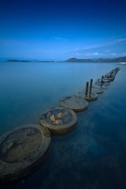 the view of the wide and clean blue sea and there are rocks lining the clear sea water with the sky dark with the blue sky and thin clouds on Tawun Sekotong beach clipart