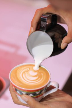 Coffee Art Pours Milk into Cup with Foam, Design, and Beverage, Perfectly Crafted on Pink Background clipart