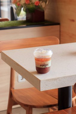 Buzlu Çay Oturur Kafe 'de, ahşap sandalyeli Masa Oturur Mükemmel bir konumda, Sessiz Kafe Atmosferinde Ferahlatıcı İçecek Solo Keyifli.