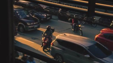 Trafik arabaları ve gün batımı ışığı olan yaya geçidi kalabalığının üzerinden geçen hava manzarası, yürüyen Asyalı insanların üzerine yükseliyor.,