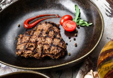 Domatesli ızgara biftek ve ahşap arka planda baharat. Et Tabakları, üst görünüm, kapat