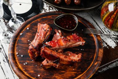 Ahşap kesim tahtasının üzerinde acılı bal biberli salamura edilmiş domuz pirzolası ve kırsal arka planda sos. Üst görünüm