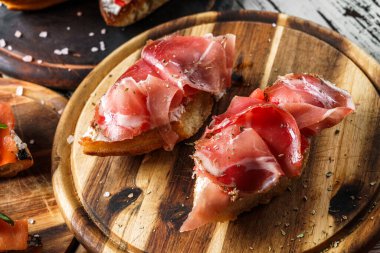 Prosciutto, dolmalık biber, ciabatta ekmeğine krem peynir, ahşap tahtada, kırsal arka planda. Sağlıklı yemek, şarap sandviçi, yakın çekim, seçici odaklanma.