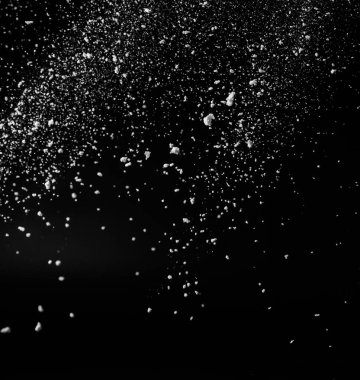 Donmuş düşen kar taneleri ya da harmanlama modu için siyah zemin üzerinde yıldız tozu. Beyaz tozun koyu arkaplandaki hareketini durdurmak, seçici odaklanma