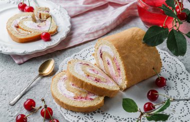 Krema ve kirazla doldurulmuş nefis sünger keki hafif arka planda peçeteye ve çilekli kiraz dalıyla. Tatlılar, tatlı ve pasta, yakın çekim, seçici odaklanma