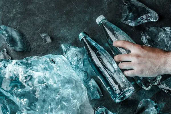 Homem Mão Segurando Garrafa Água Gelo Pedaços Gelo Iluminado Com — Fotografia de Stock