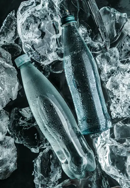 Dos Botellas Agua Hielo Piezas Hielo Iluminadas Con Luz Azul —  Fotos de Stock