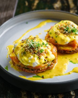 Somon dilimli nefis krep, Benedict yumurtaları ya da kaynatılmış yumurta, susam ve mermer masada buzlu içecekle birlikte mikroyeşillikler. Sağlıklı kahvaltı, diyet, üst manzara