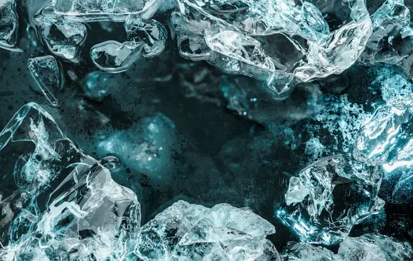 碎冰碎片在黑色背景上闪烁着蓝光 摘要冰结构背景 顶视图 — 图库照片