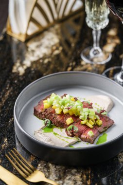 Meyveli biftek, sebzeli az pişmiş biftek ve mermer arka plandaki tabakta püre ve içeceklerle birlikte. Et yiyecekler, üst manzara.