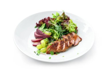 Orta pişmiş biftek, armut, üzüm, marul, roka ve beyaz arka planda izole edilmiş soslu sağlıklı salata. Sağlıklı yemek, en iyi manzara.