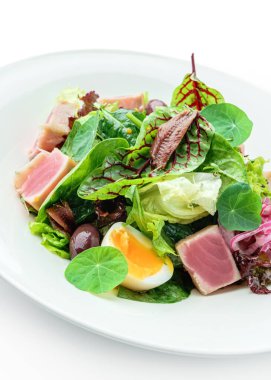 Kurutulmuş ton balığı, marul, yumurta, zeytin, soğan ve soslu sağlıklı salata. Beyaz arka planda izole edilmiş. Sağlıklı yemek, en iyi manzara.
