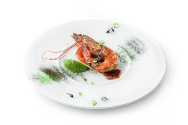 Limonlu ızgara kaplan karidesi, mikroyeşiller ve beyaz arka planda izole edilmiş tabakta sos. Sağlıklı deniz ürünleri, manzaralı.