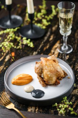 Sebze püresiyle ızgara bıldırcın ve şarap bardaklarıyla mermer masada sos. Sağlıklı yemek, yakın çekim, üst manzara.