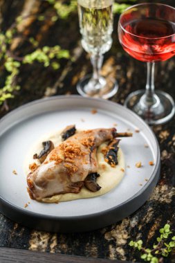 Patates püresiyle pişirilmiş tavşan eti ve şarap bardaklarıyla mermer masada mantar tabağı. Sağlıklı yemek, yakın çekim, üst manzara.