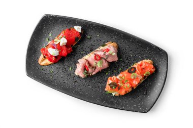 Jambonlu lezzetli bruschetta, somon balıklı bruschetta ve beyaz arka planda izole edilmiş fırında dolmalık biberli bruschetta. Sağlıklı kahvaltı, yakın çekim, üst manzara.