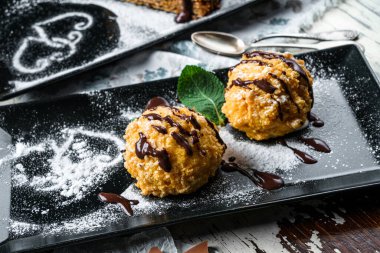 Kremalı çıtır kekler ve ahşap arka planda çikolata. Tatlılar, tatlı ve pasta, üst manzara