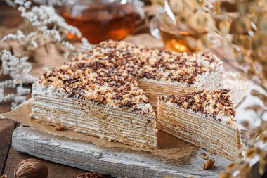 Ekşi kremalı, fındıklı, fındıklı, çay ve çiçekli, katmanlı ballı kek. Tatlılar, tatlı ve pasta, üst manzara, kapat.